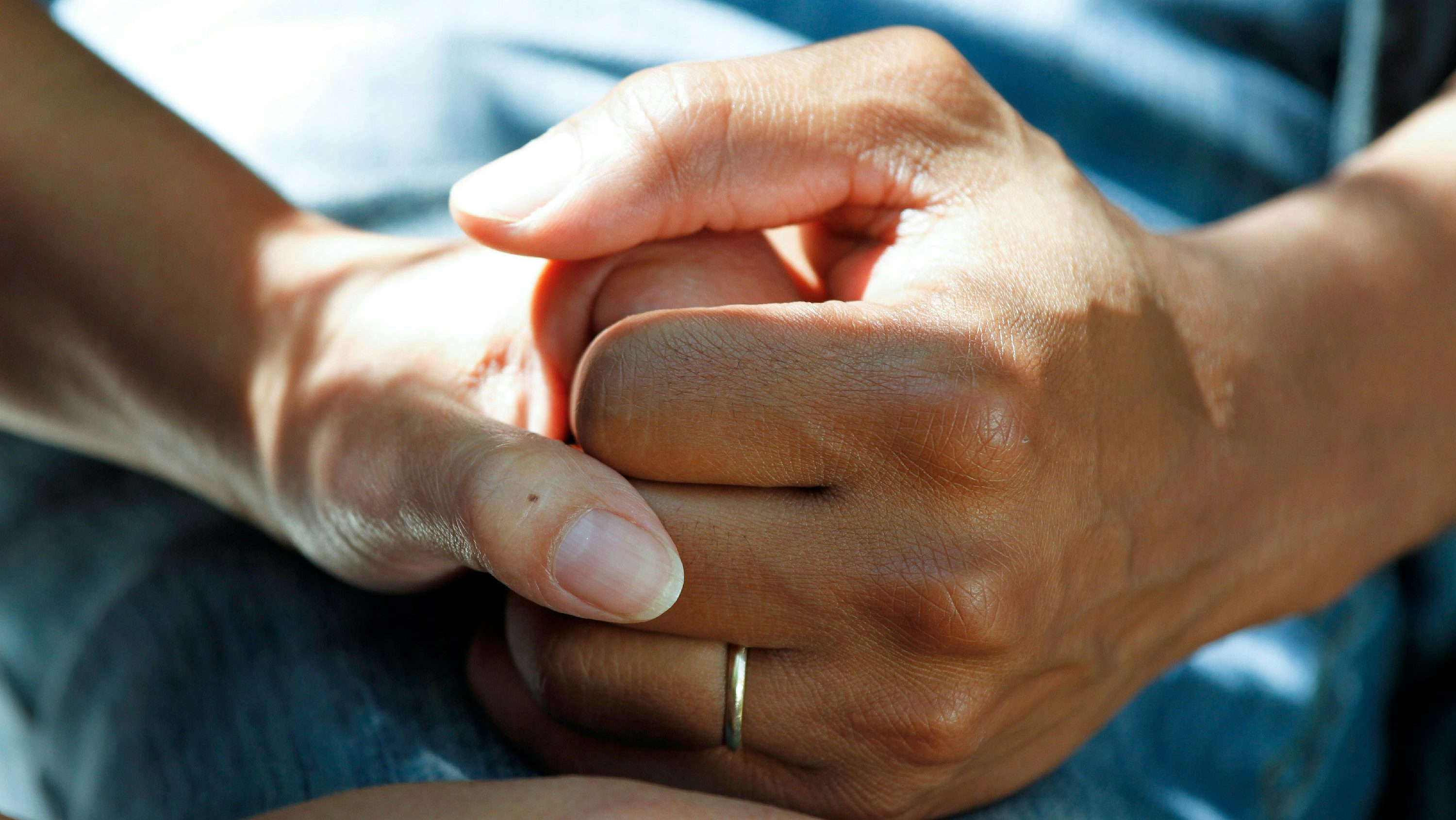 Two hands holding each other tight.