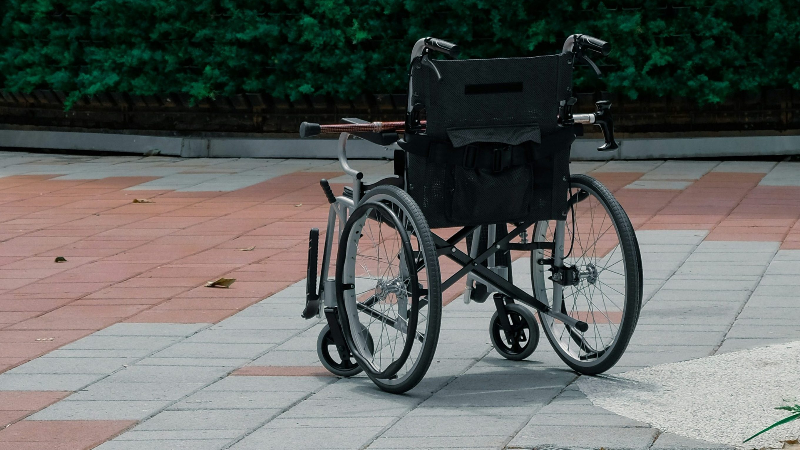 Empty wheel chair outdoors on a paved floor.