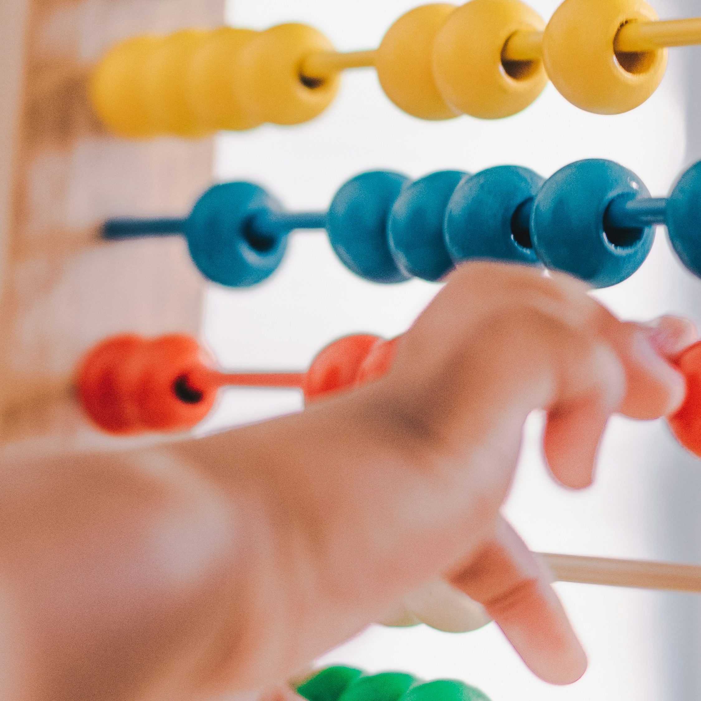 Colorful abacus with a child's hand moving the units.