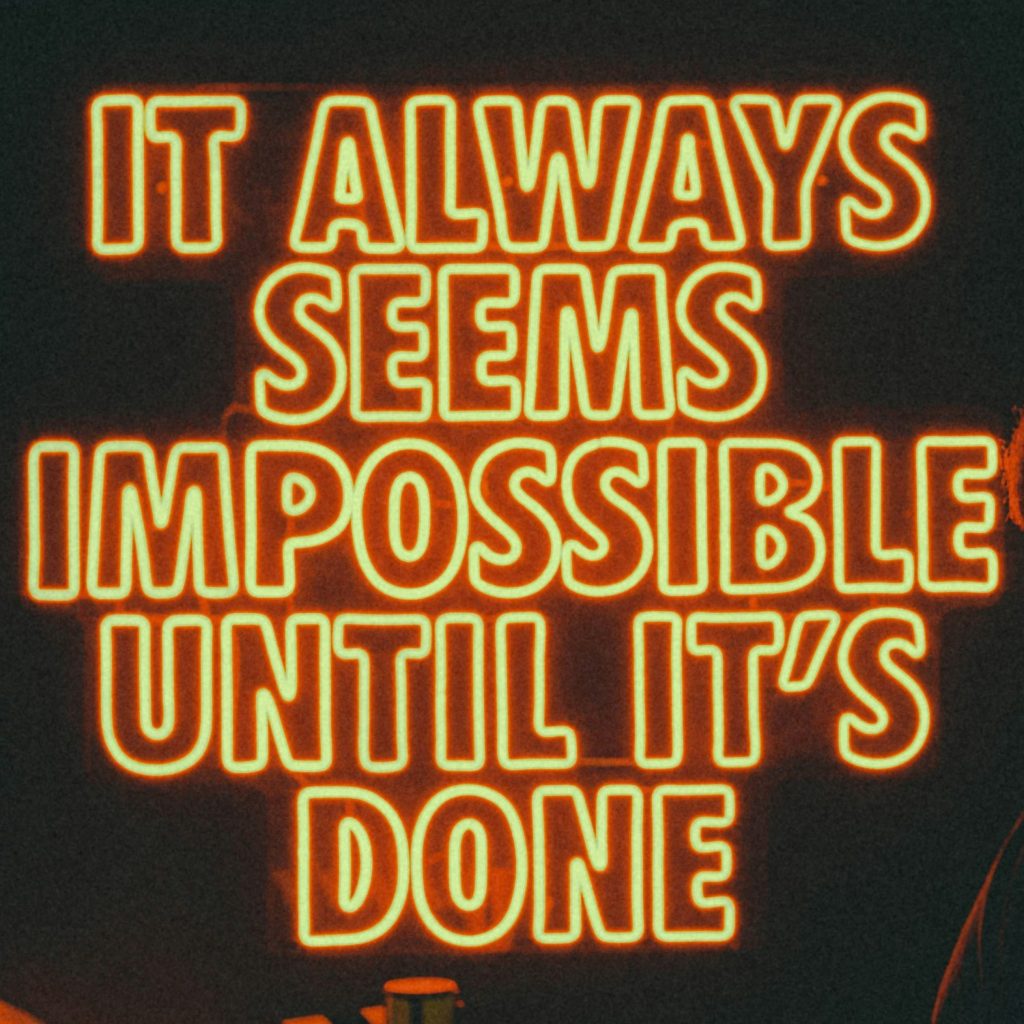 Neon sign saying "It always seems impossible until it's done".
